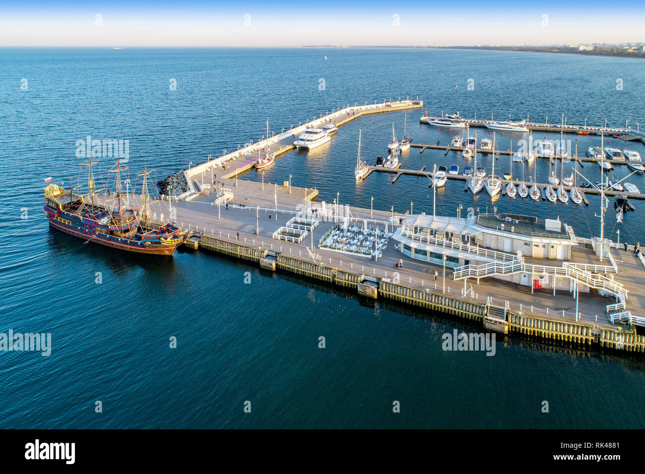 Wooden pier with harbor, pirate tourist ship and marina with yachts in Sopot resort near Gdansk in Poland in sunset light. Aerial view Stock Photo