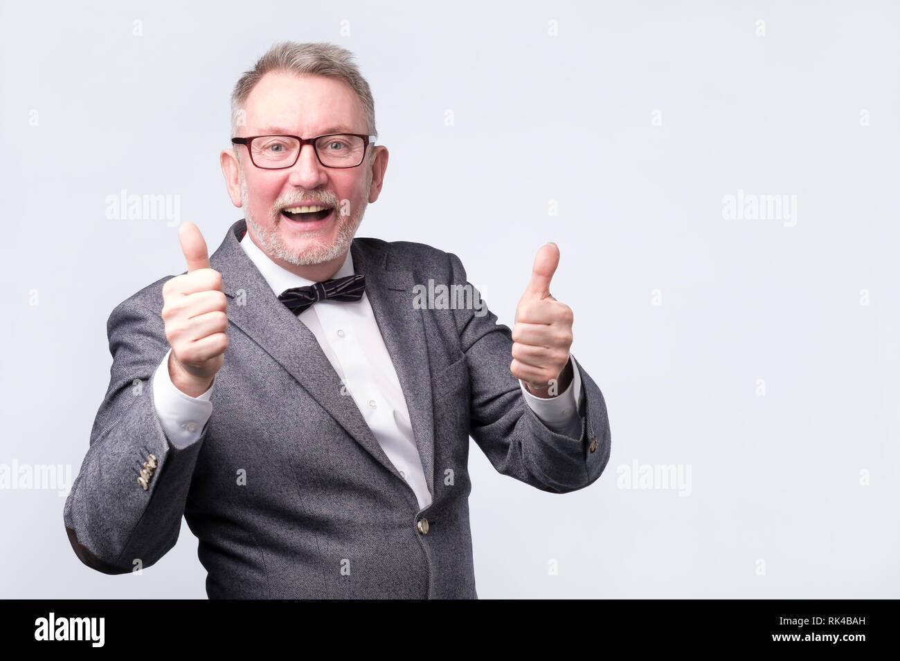 senior business man with bow tie showing thumbs up Stock Photo