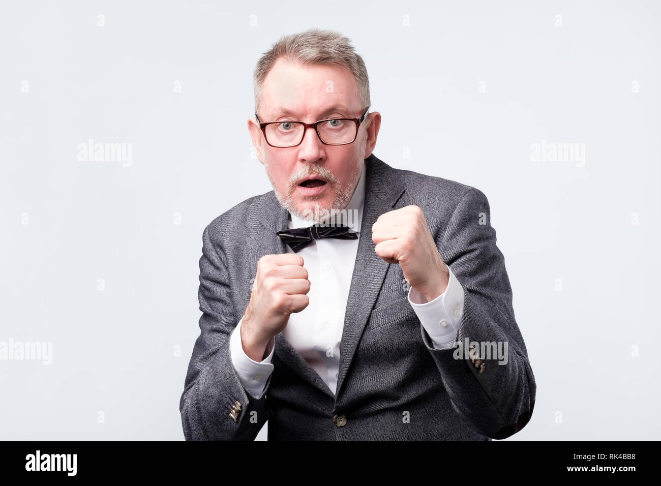 Handsome senior man punching fist to fight, aggressive and angry attack Stock Photo