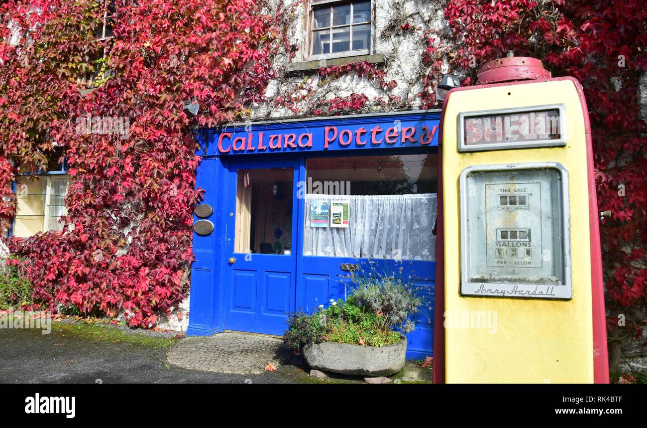 The house of the Callura Pottery with a blue front door and front window. In front of the house is an ancient gasoline pump. Mountshannon, County Clar Stock Photo