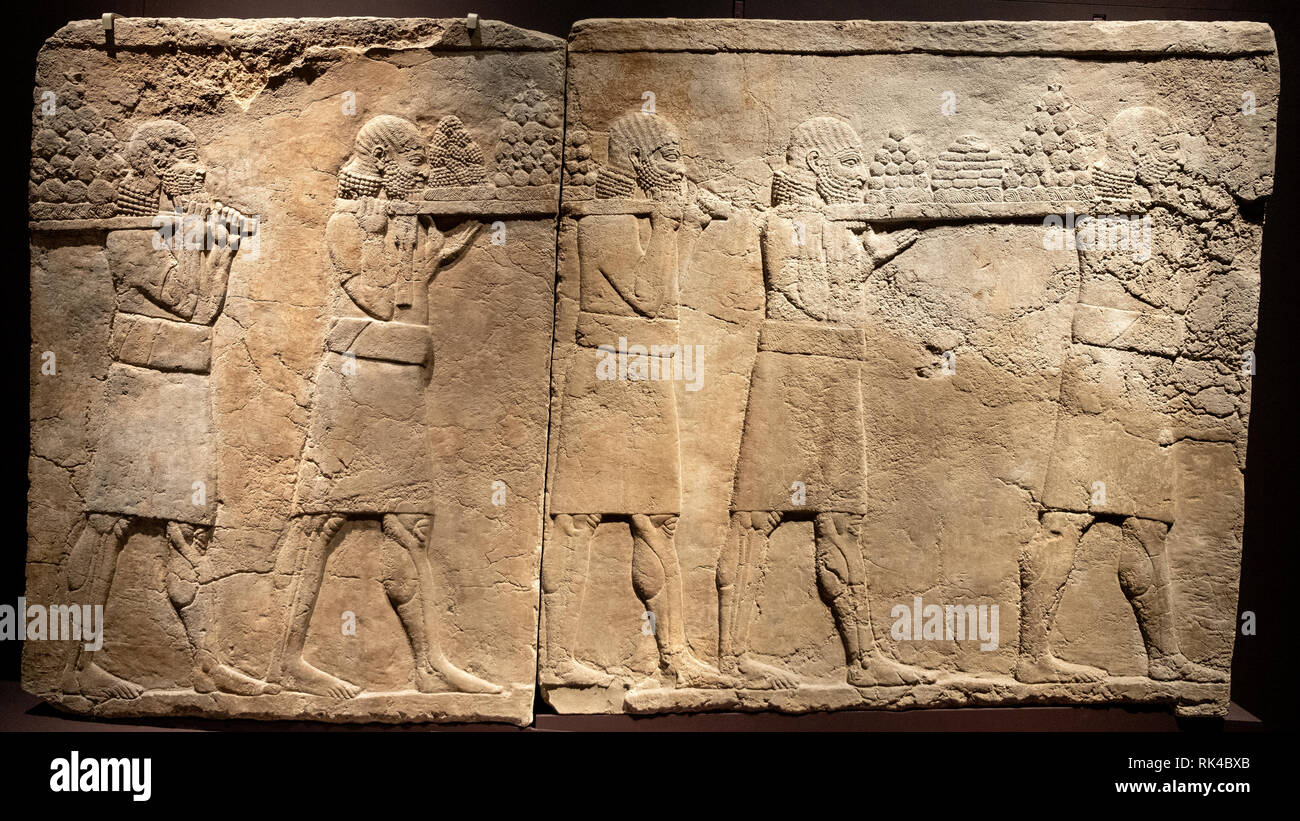 London, England / United Kingdom - 2019/01/28: Ancient Assyria clay tablet relief of royal banquet from king Ashurbanipal royal palace in Nineveh at t Stock Photo