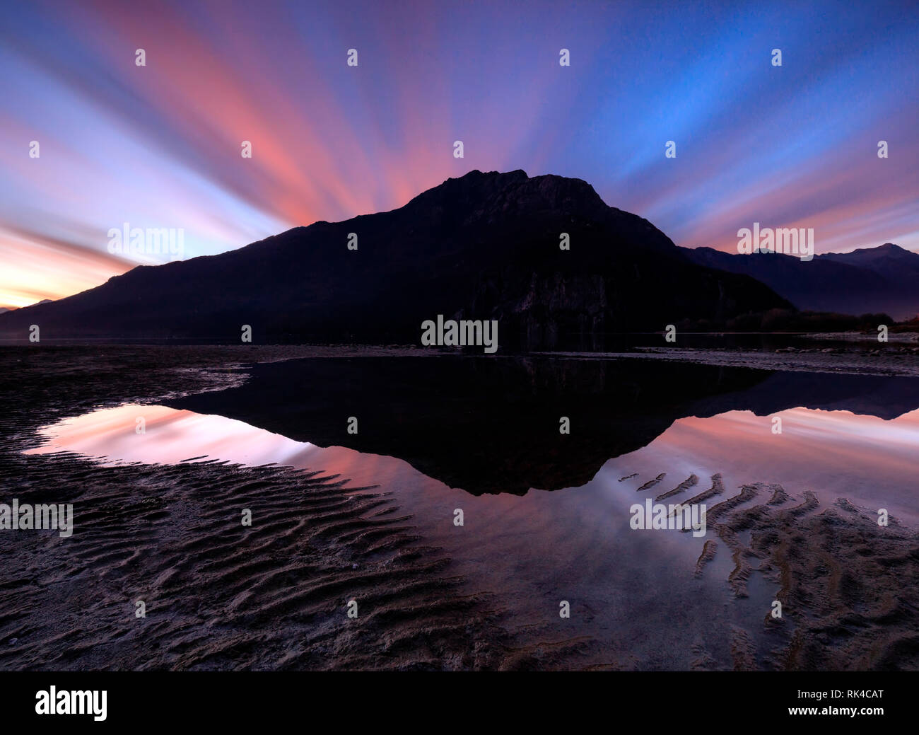 Sunset clouds mirroring in water, Novate Mezzola, Chiavenna Valley, Sondrio province, Valtellina, Lombardy, Italy Stock Photo