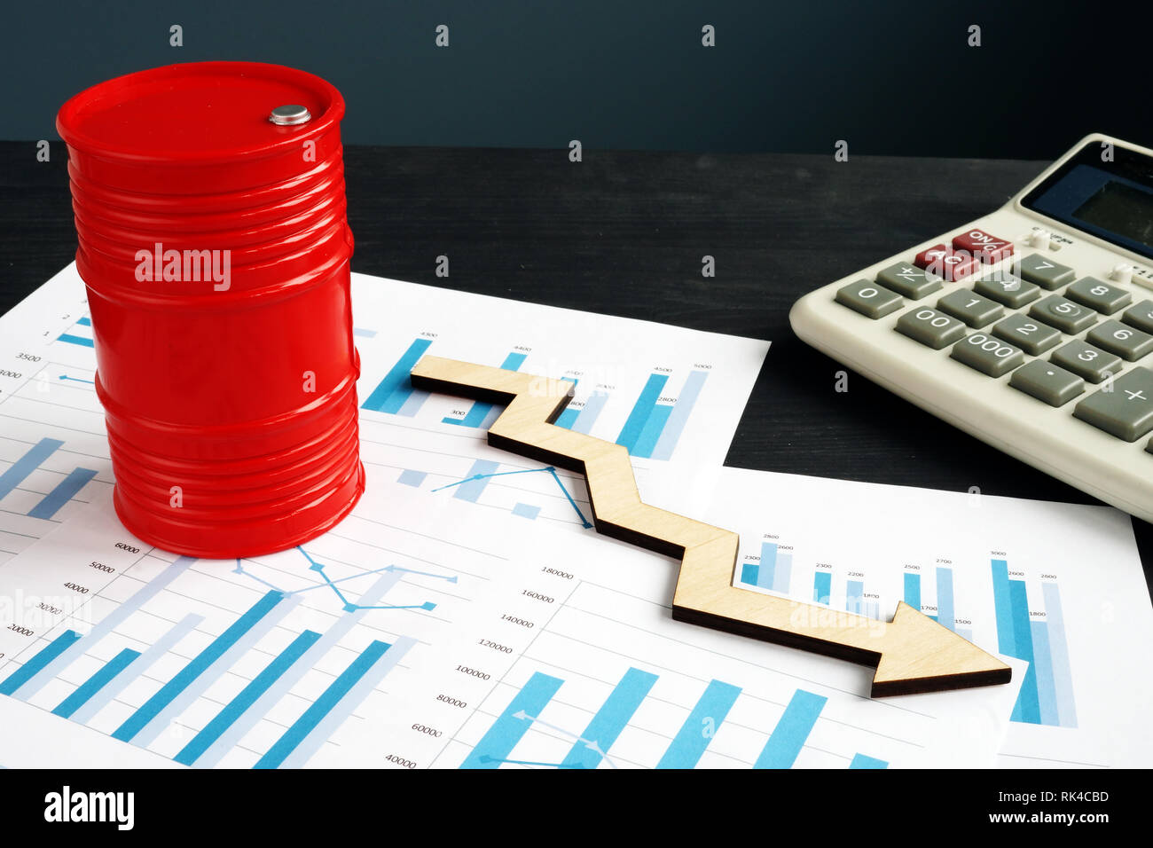 Oil prices falling. Barrel with arrow on the financial papers. Stock Photo