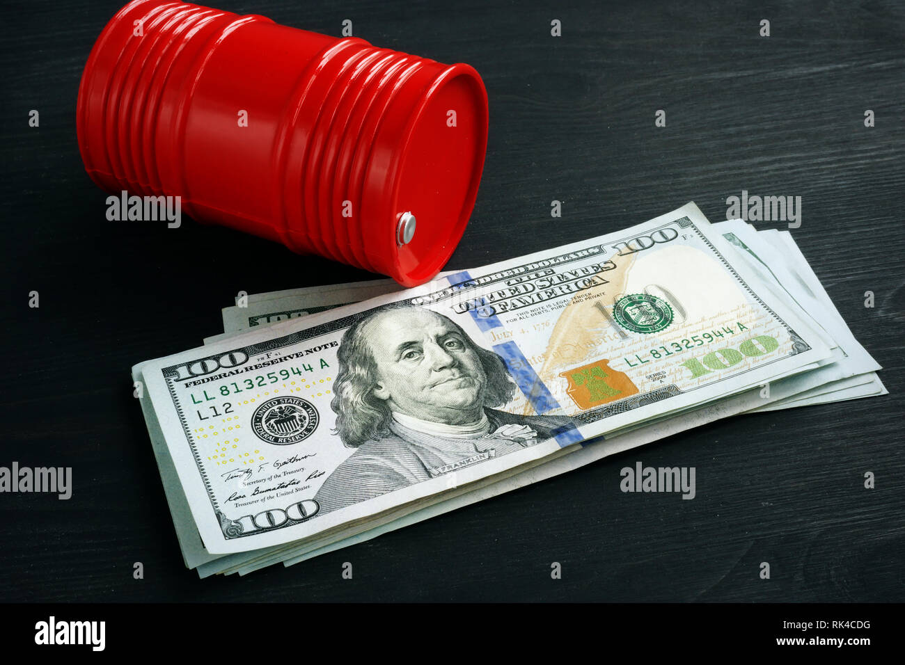 Red oil barrel and money. Oil price and trading. Stock Photo
