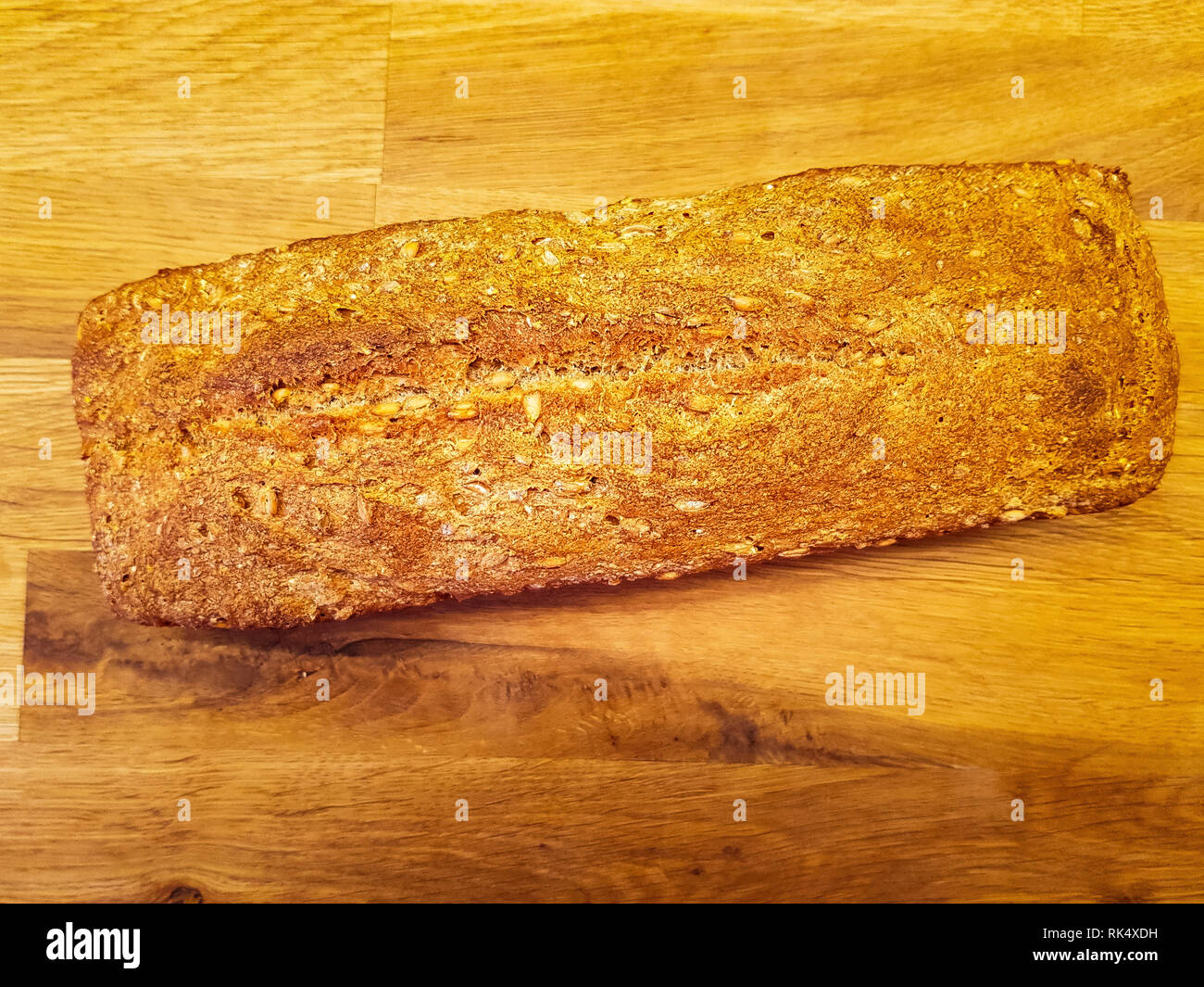 A complete homemade whole grain bread loaf on a wooden table Stock ...