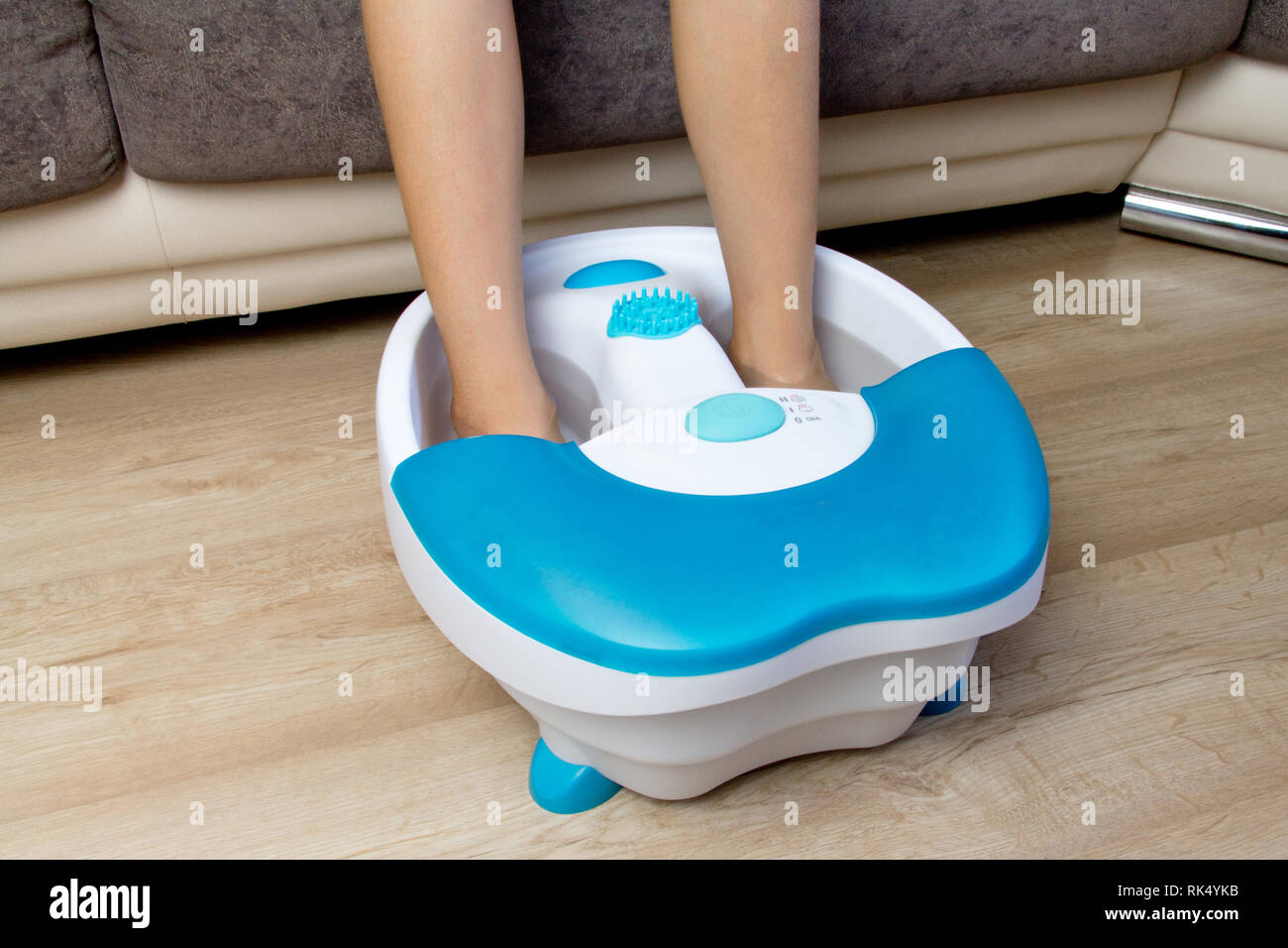 Feet in a vibrating foot massager. Electric massage bath. Foot bath before a pedicure Stock