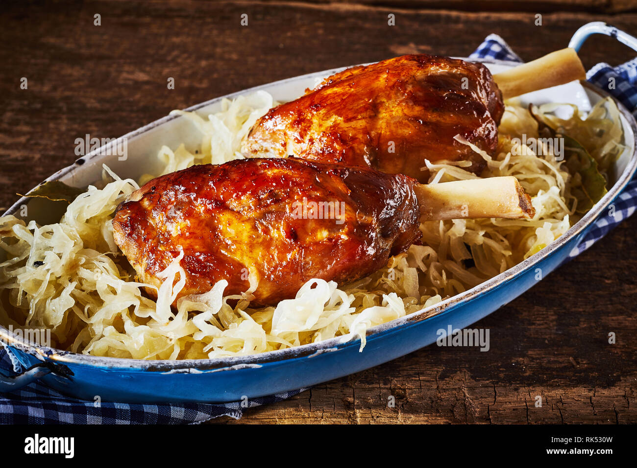 Roasted eisbein or German pork knuckles served on a bed of shredded