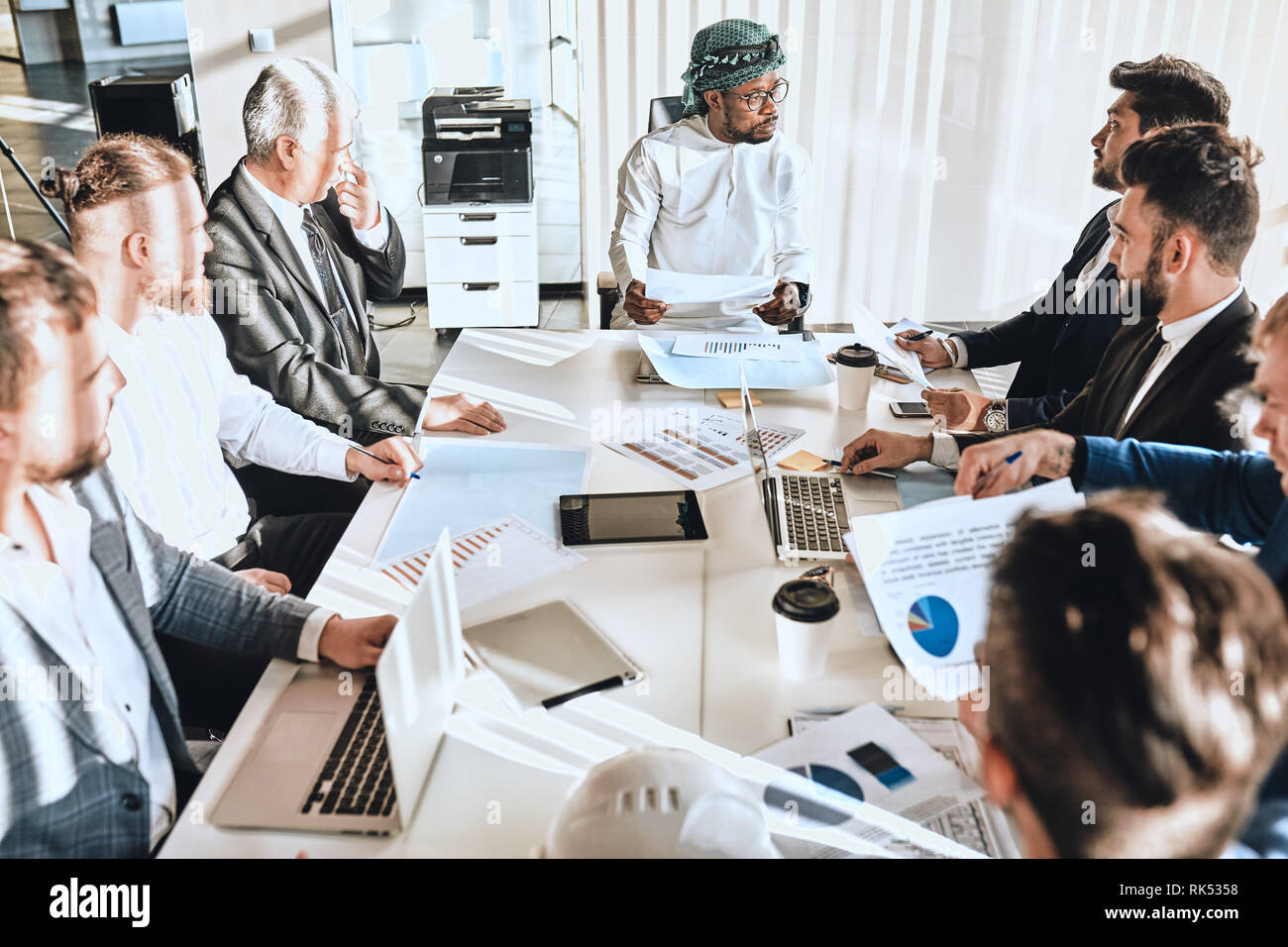 arabic boss is sharing with his knowledge with colleagues. formal ...