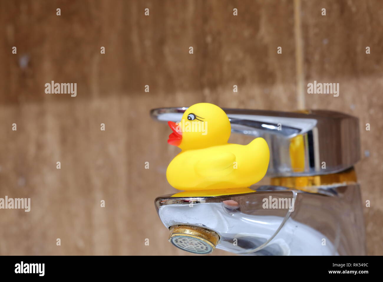 Rubber Duck As A Decoration Of The Bathroom Interior Near The Tap