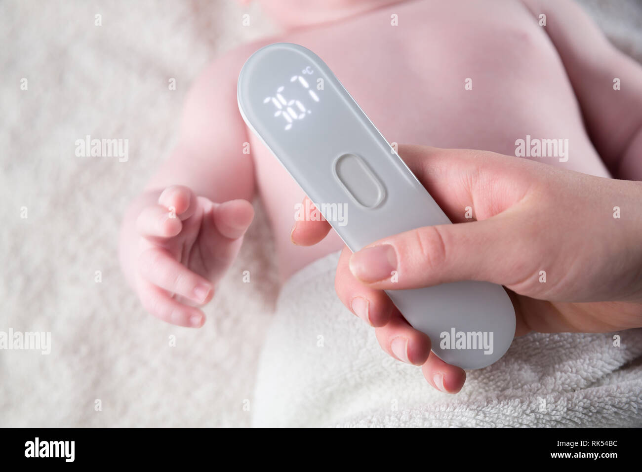 Close Up of mother hand taking temperature measurement of infant baby