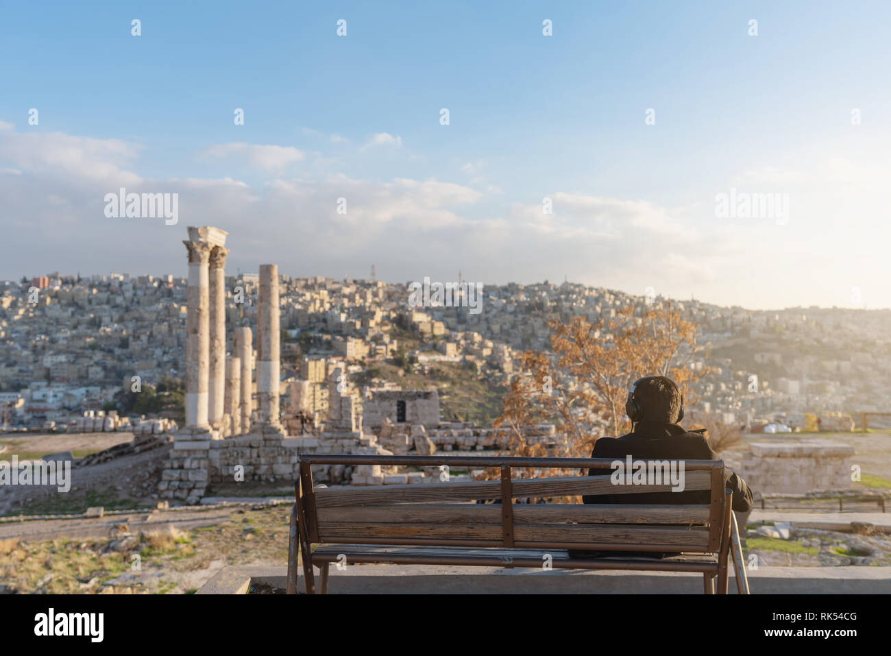 a man sitting alone listening music by headphone in spring at Citadel in Amman, Jordan Stock Photo