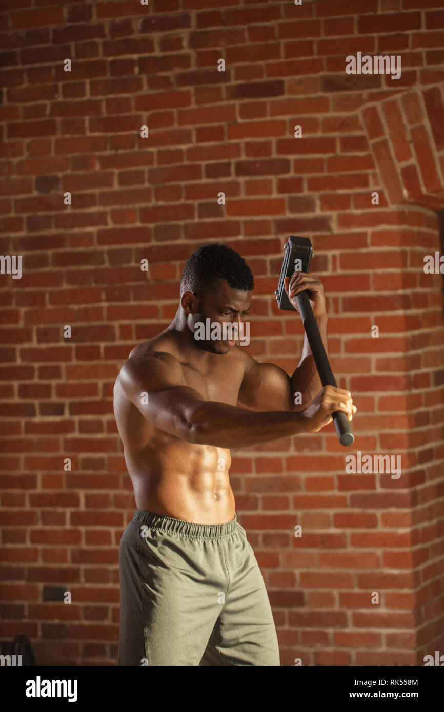 Muscular man hitting wheel tire with hammer sledge Stock Photo Alamy