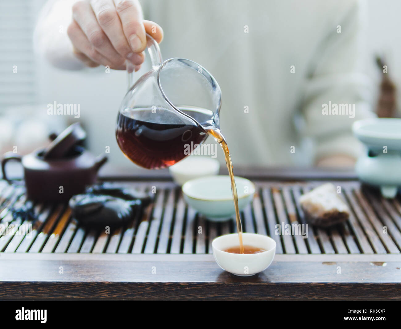 Chinese tea ceremony. Master pouring puer tea in cups. Pu erh tea ceremony. Stock Photo