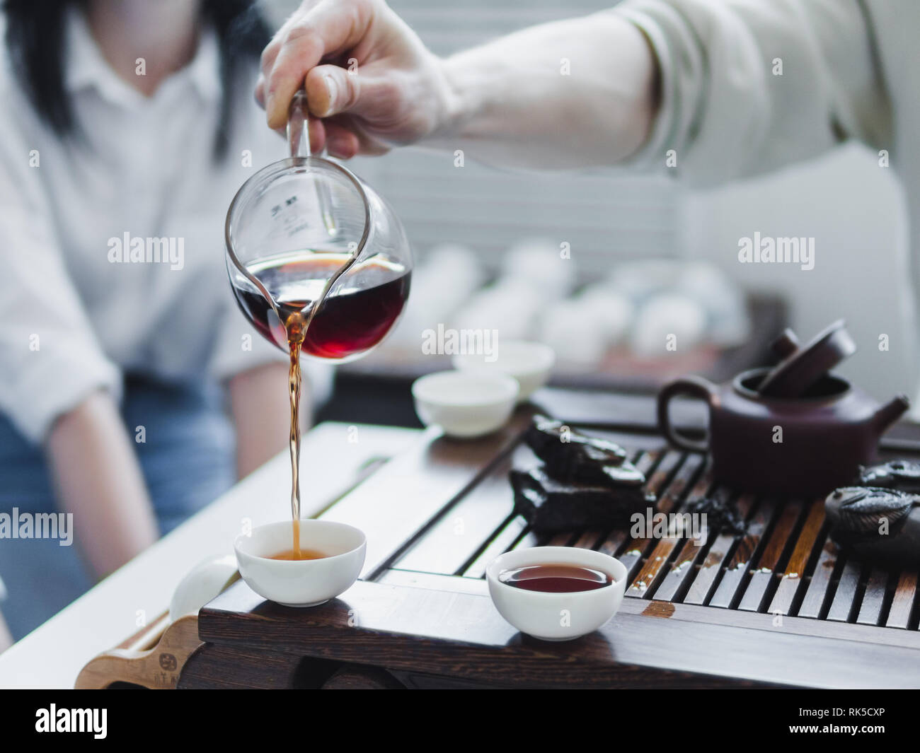 Chinese tea ceremony. Master pouring puer tea in cups. Pu erh tea ceremony. Stock Photo