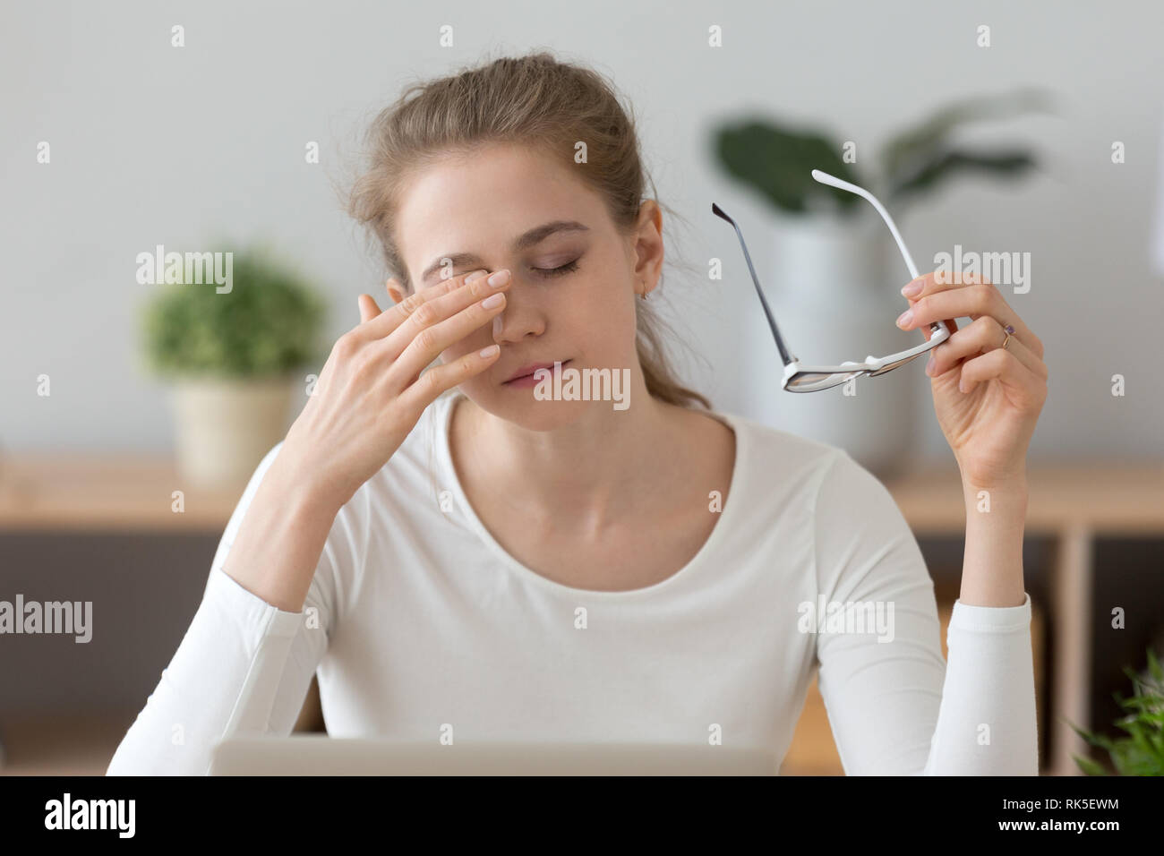 Fatigued girl taking off glasses rubbing eyes feeling eye strain Stock Photo Alamy