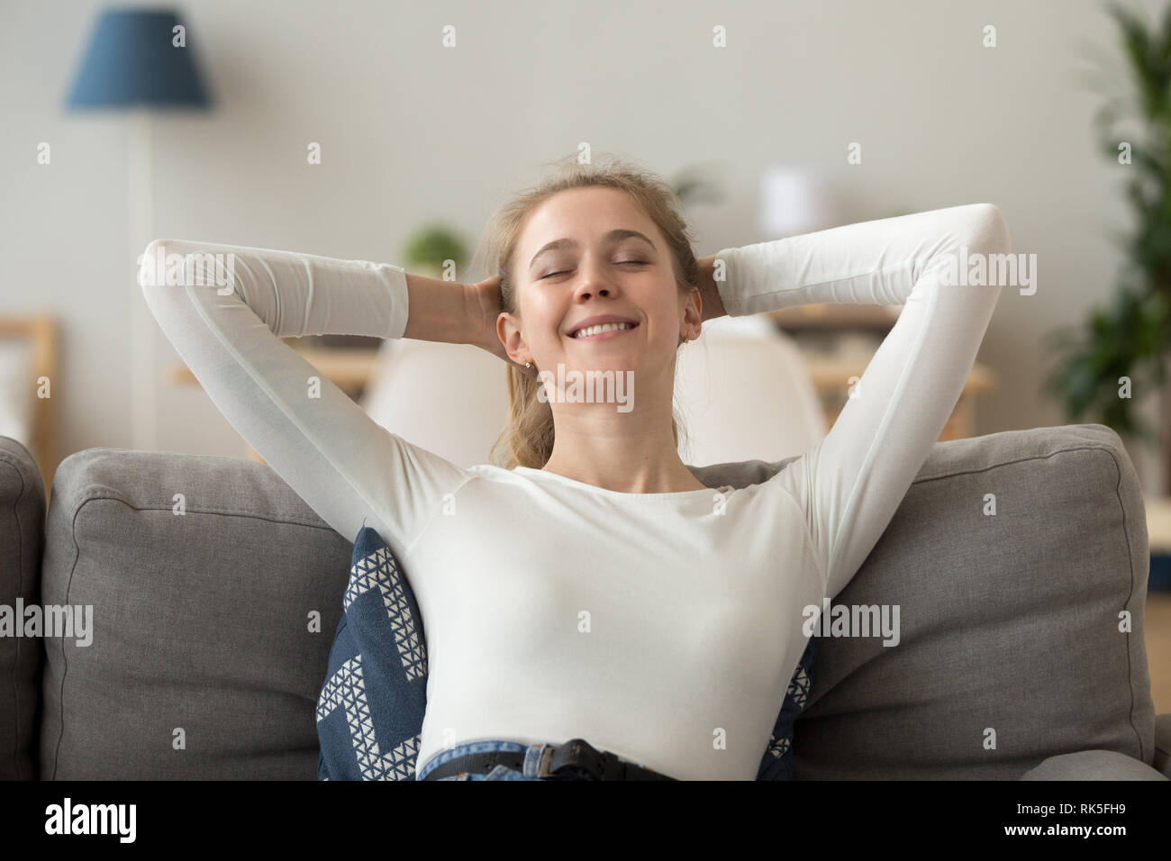 Relaxed happy woman resting on comfortable couch breathing fresh air Stock Photo