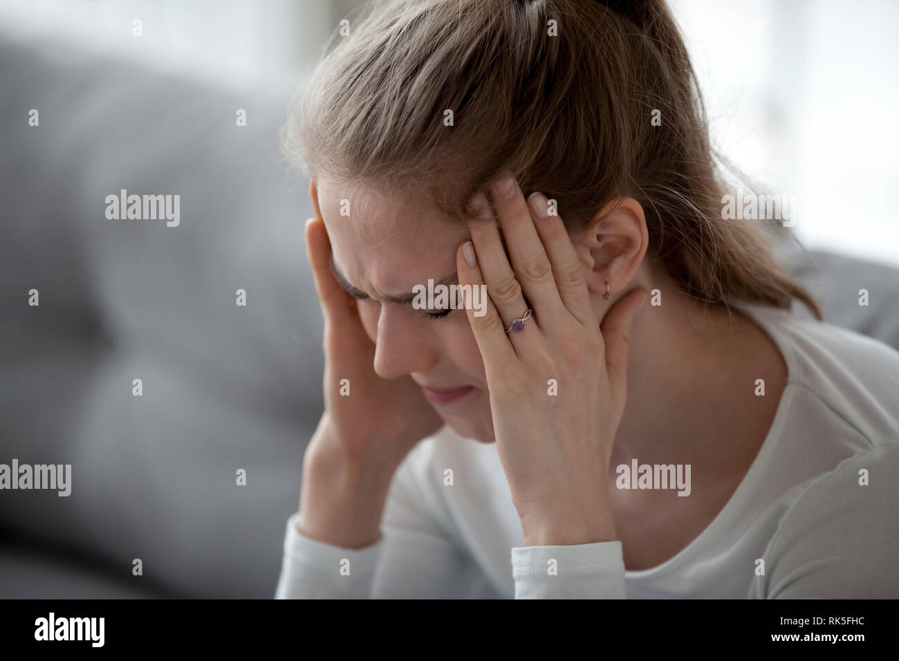 Stressed young sick woman having strong terrible headache massaging ...