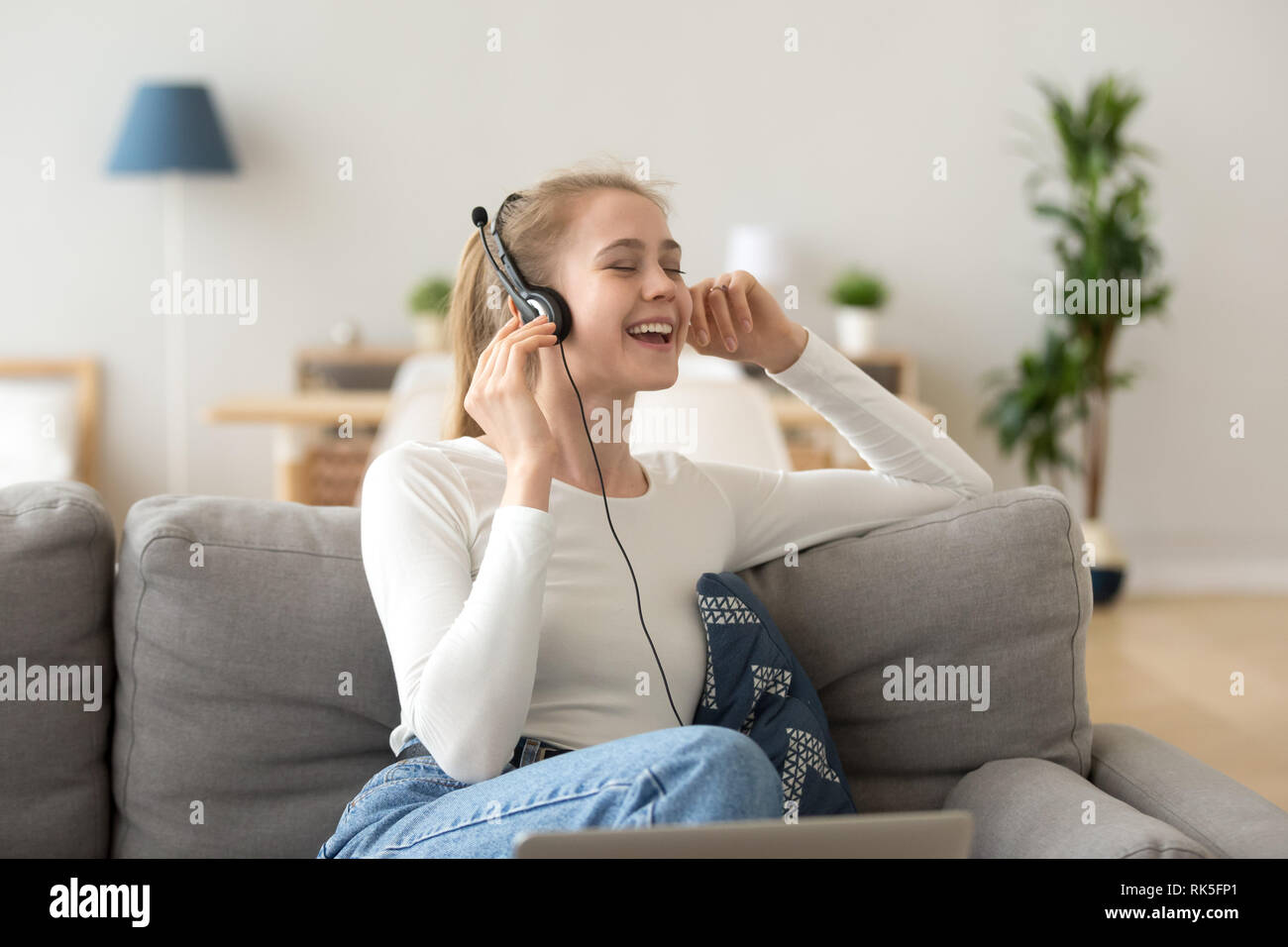 Relaxed smiling woman in headphones enjoying good music at home Stock Photo