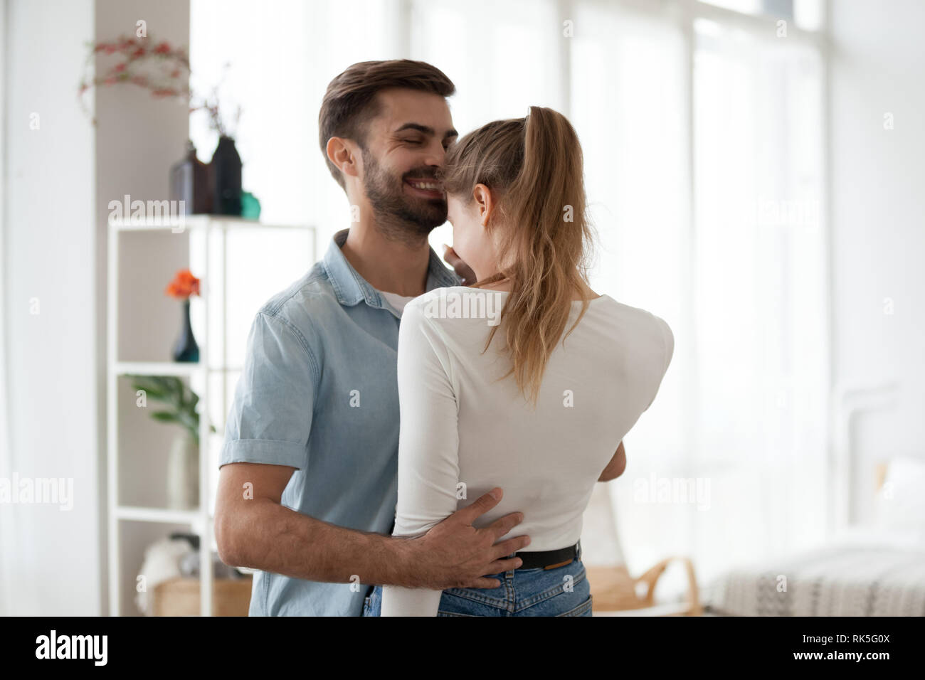 Young happy romantic couple in love dancing cuddling at home Stock Photo