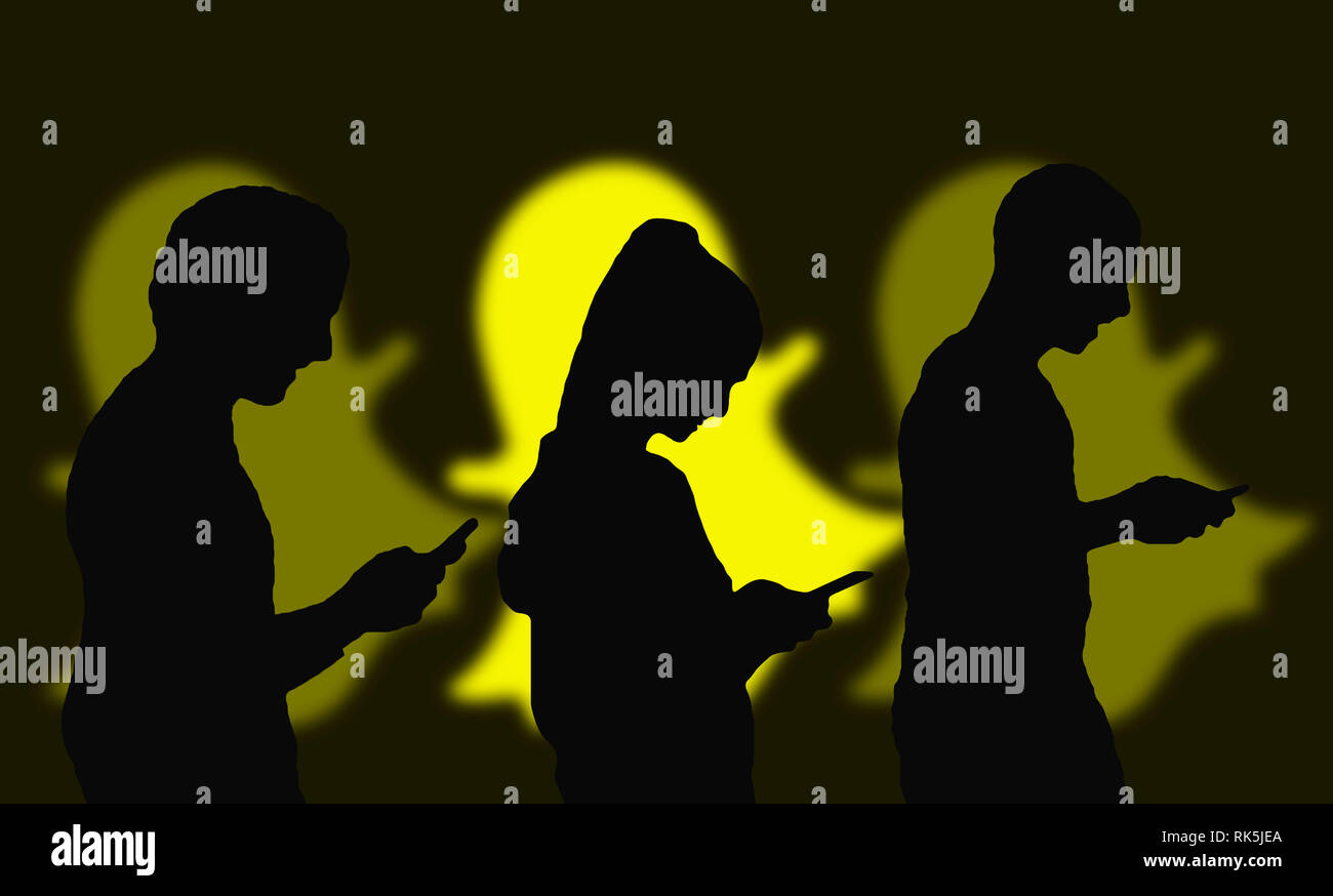 Silhouettes of several people sharing photos online using the Snapchat app on smartphones. Stock Photo