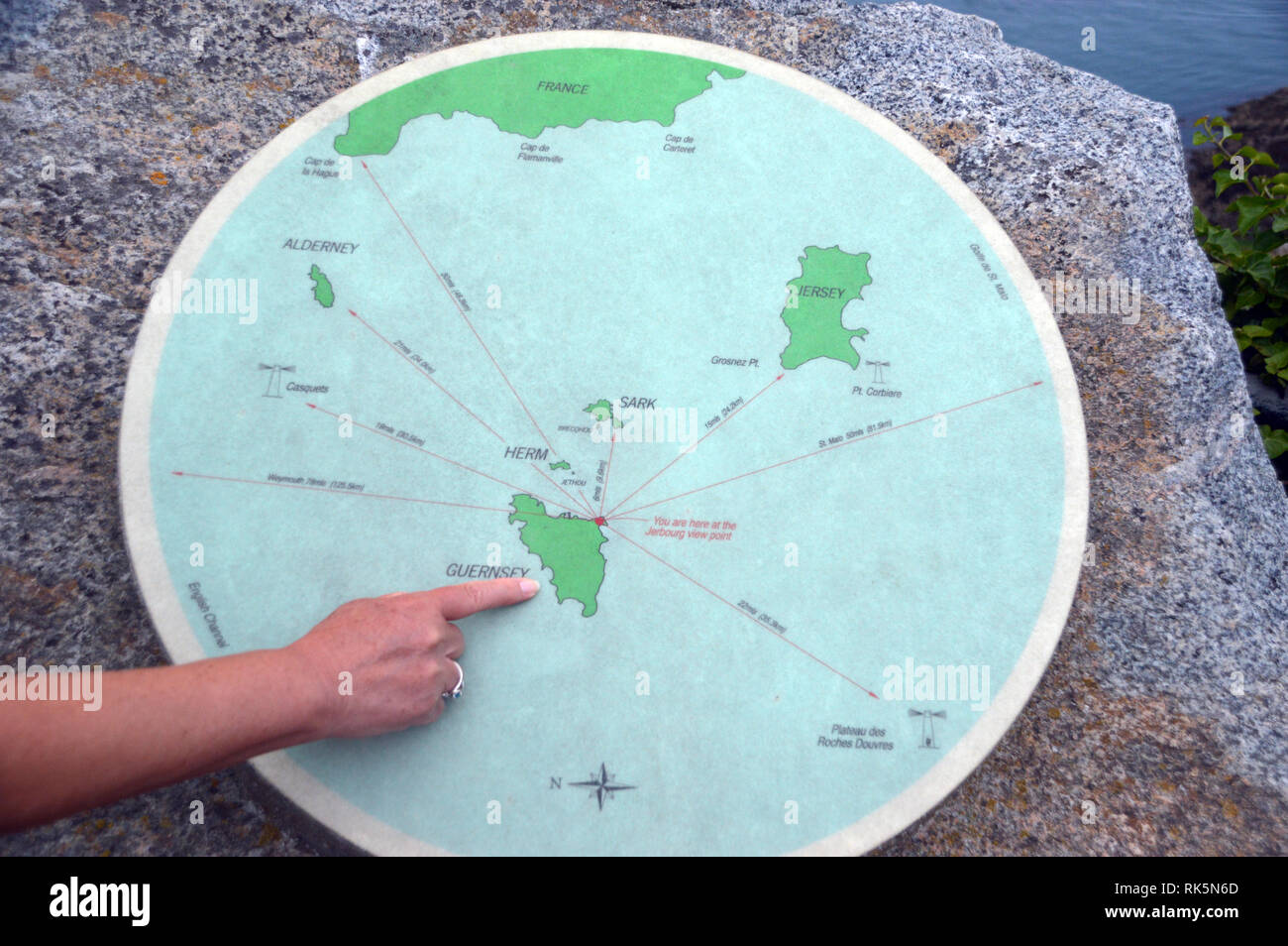 Woman's Finger Pointing to Guernsey on a Map on the Headland of Jerbourg Point on the Coastal Path on Guernsey, Channel Islands.UK. Stock Photo