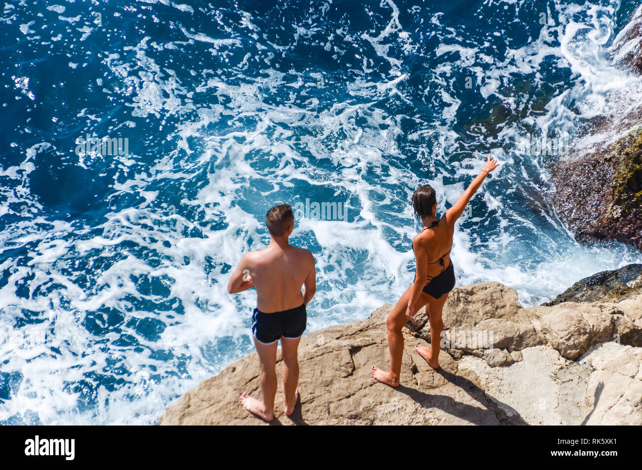 Couple contemplating cliff jumping into the Adriatic in Dubrovnik, Croatia Stock Photo