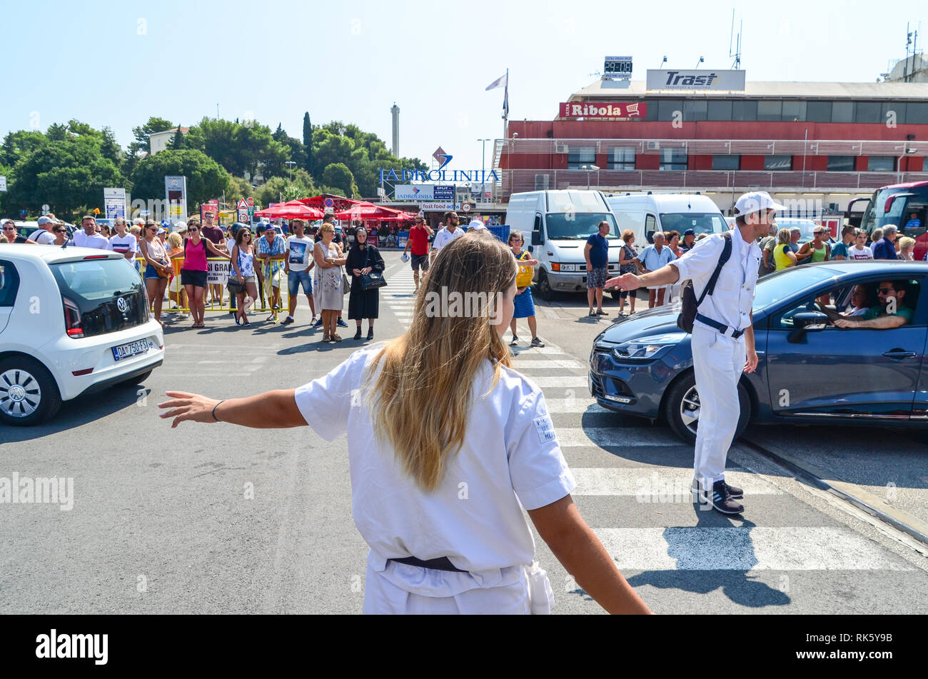 Agents guiding cars into the ferries in Split, Croatia Stock Photo - Alamy