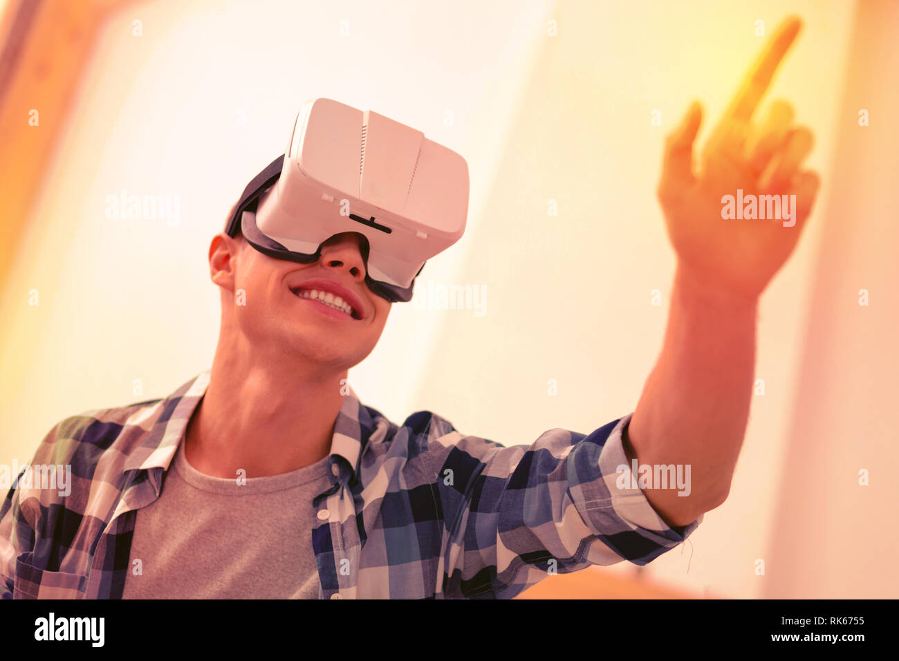 Joyful glad guy experimenting in virtual reality Stock Photo