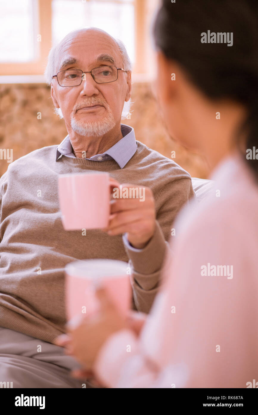 Upset old man being deep in his thoughts Stock Photo