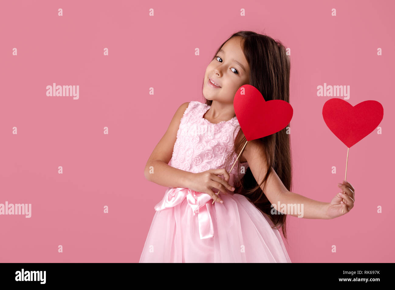 Happy Cute Little Girl In A Pink Dress Holding Two Paper Heart On A Pink Background St Valentine S Day Stock Photo Alamy