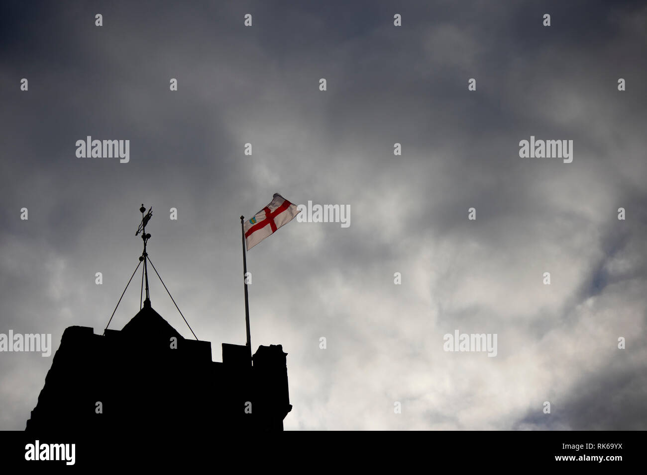 English Saint George flag flying over a Silhouetted medieval church ...