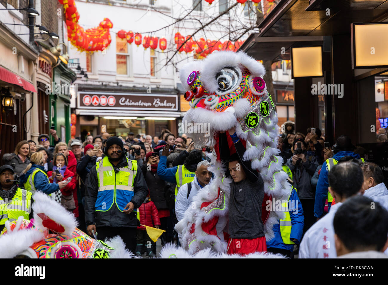 London, UK. 09th February, 2019. People watching dancers performing a dragon dance in front of one of the restaurants during the Chinese New Year celebrations in London Chinatown, UK. Stock Photo