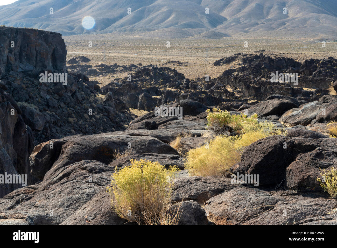 Looking across rocky desert landscape with valley and mountains beyond . Stock Photo