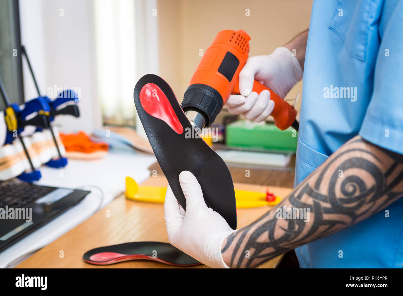 Closeup Hands Of Young Man With Tattoo In Workshop Dressed In Blue