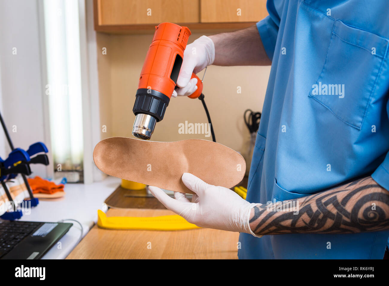 Closeup Hands Of Young Man With Tattoo In Workshop Dressed In Blue