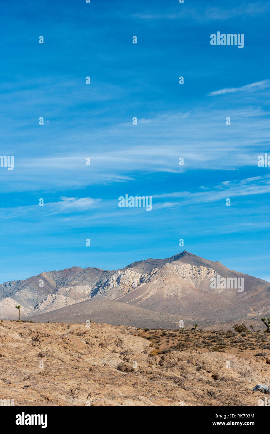 Morning in the Mojave Desert with tall barren mountains under bright