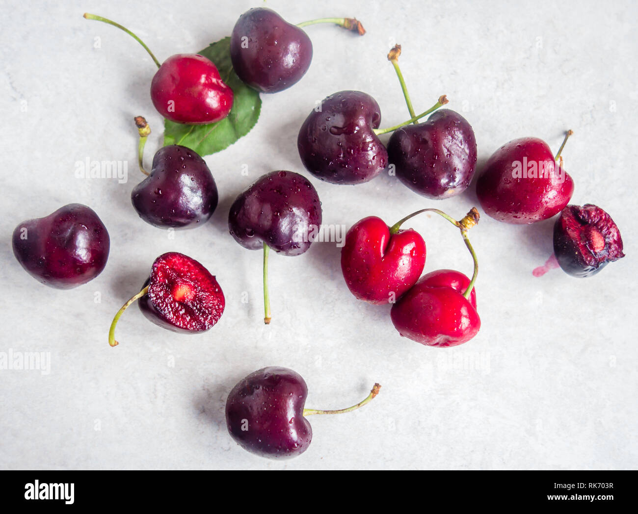 Scattered red cherries with stems on white background Stock Photo
