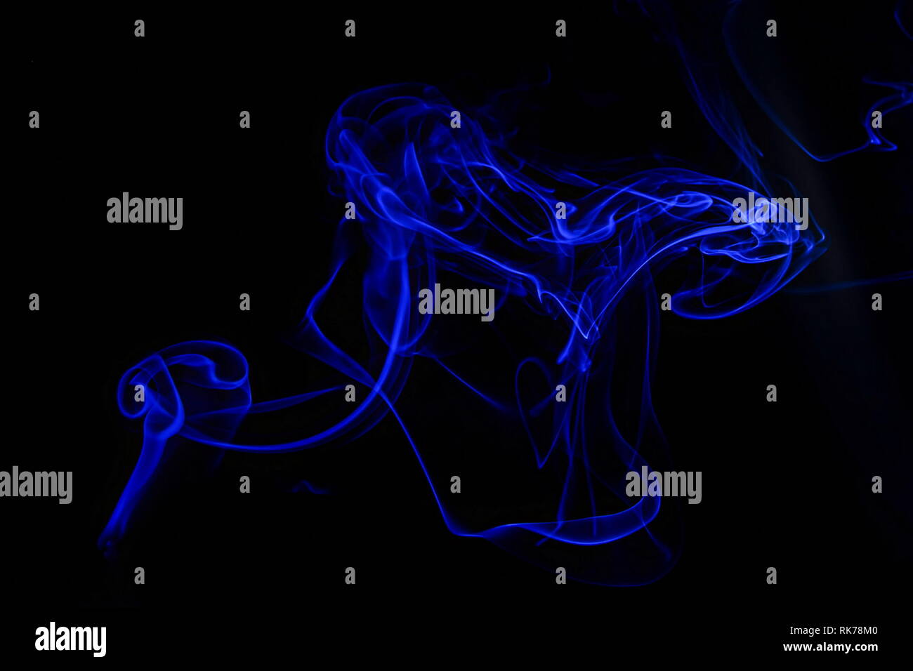 Abstract blue smoke swirls over black background Stock Photo - Alamy