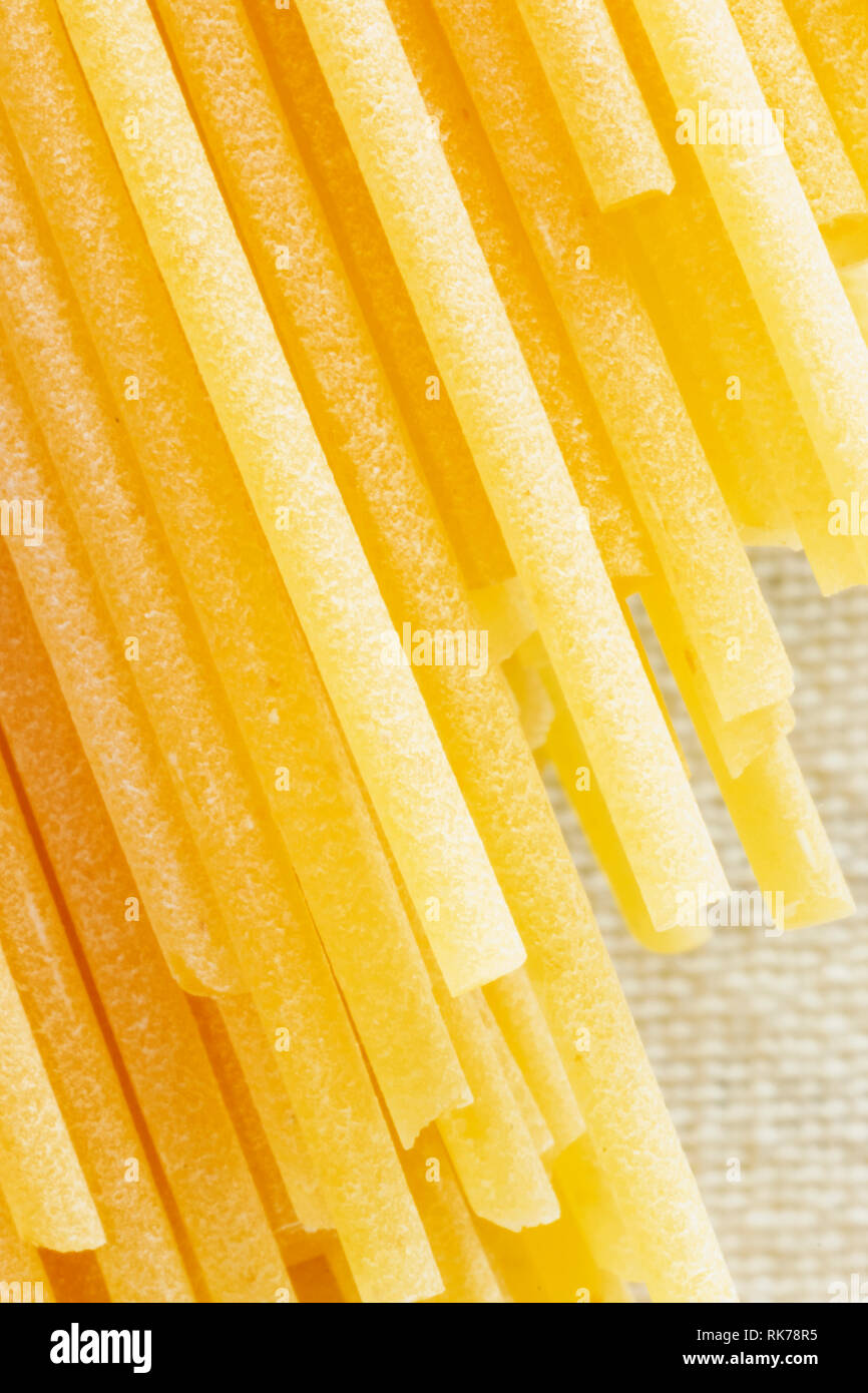 Dried pasta spaghetti on a white background, long and thin solid