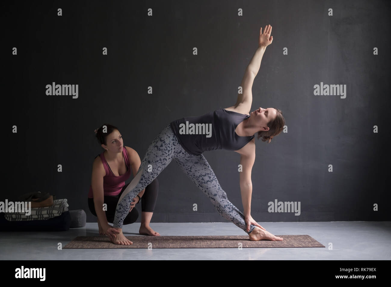 Yoga class instructor and beginner making asana exercises. Stock Photo