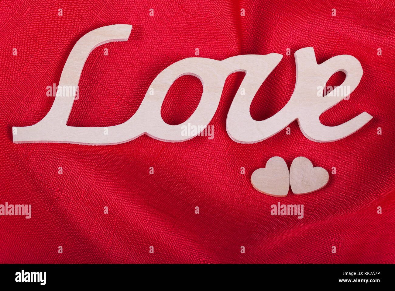Valentine's day concept horizontal photo, love the word and two hearts on a red background Stock Photo