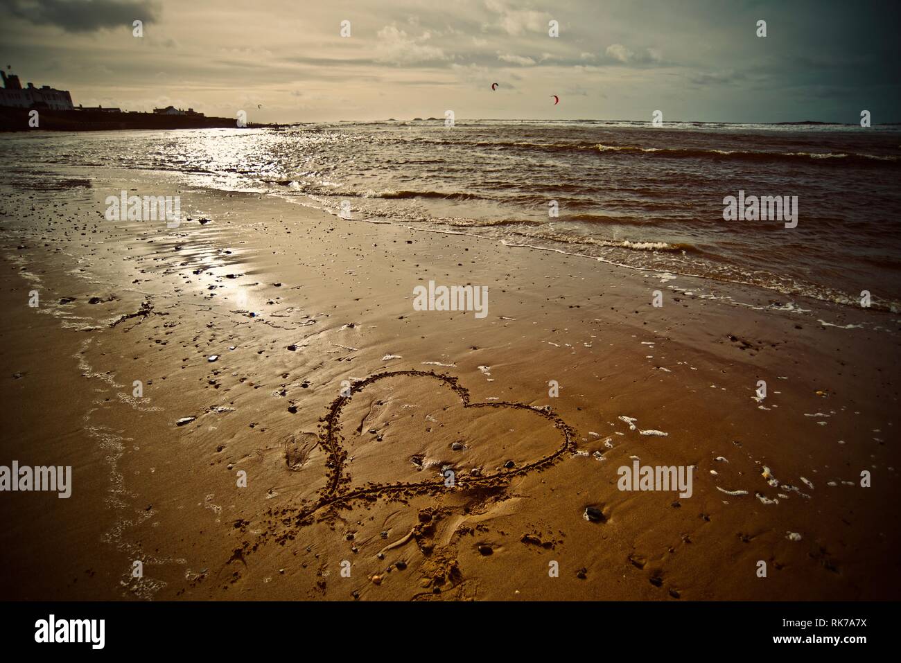 Love the beach, love the sea. A heart drawn in the sand of a beach with the tide coming in, Rhosneigr, Anglesey, North Wales, UK Stock Photo