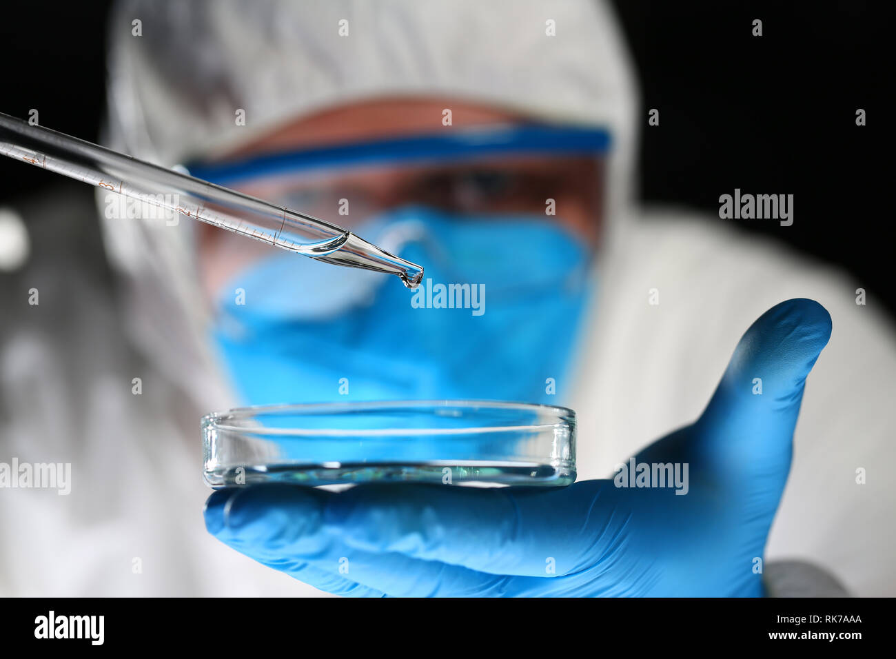 Male chemist look at microscope hold test tube Stock Photo