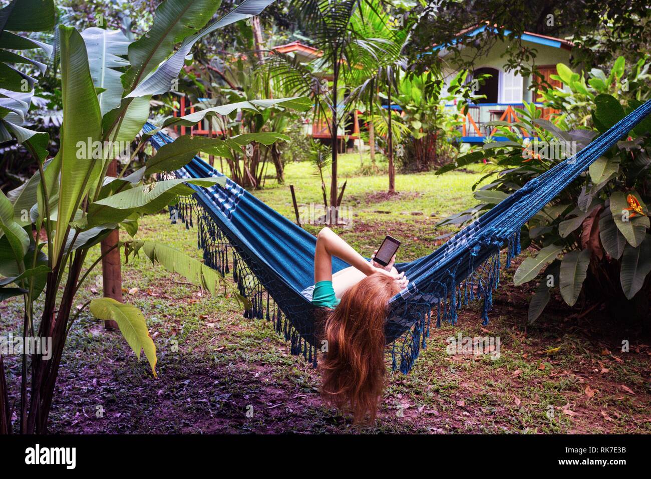 girl lying in a hammock and read the book at the garden Stock Photo - Alamy