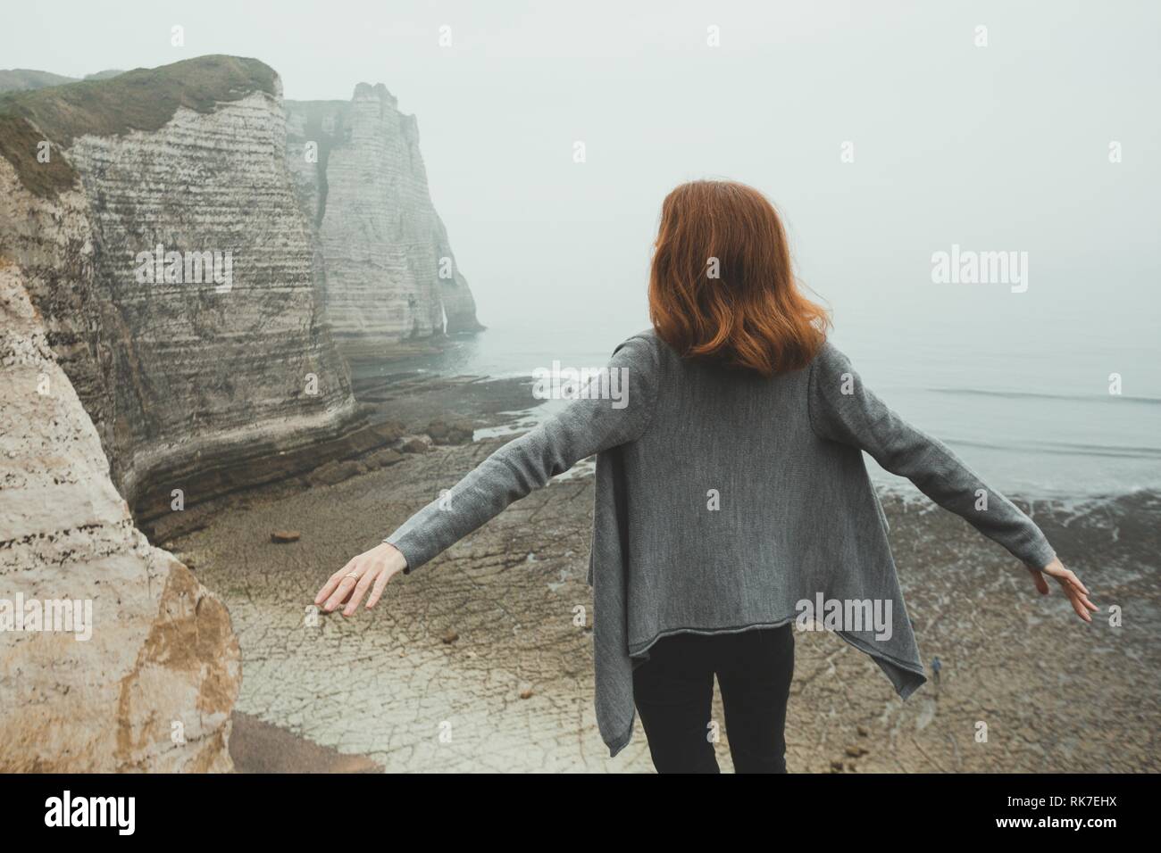 girl standing at the edge of rock in the Etretat. France Stock Photo ...