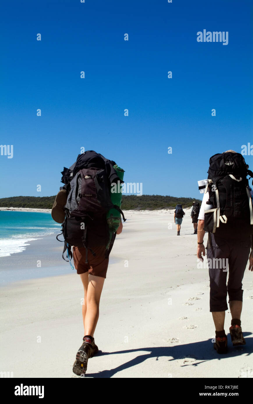 Guests of Cradle Mountain Huts walk along a remote beach on the Bay of Fires walk, a four-day hike that traverses Tasmania's far north-east coastline. Stock Photo