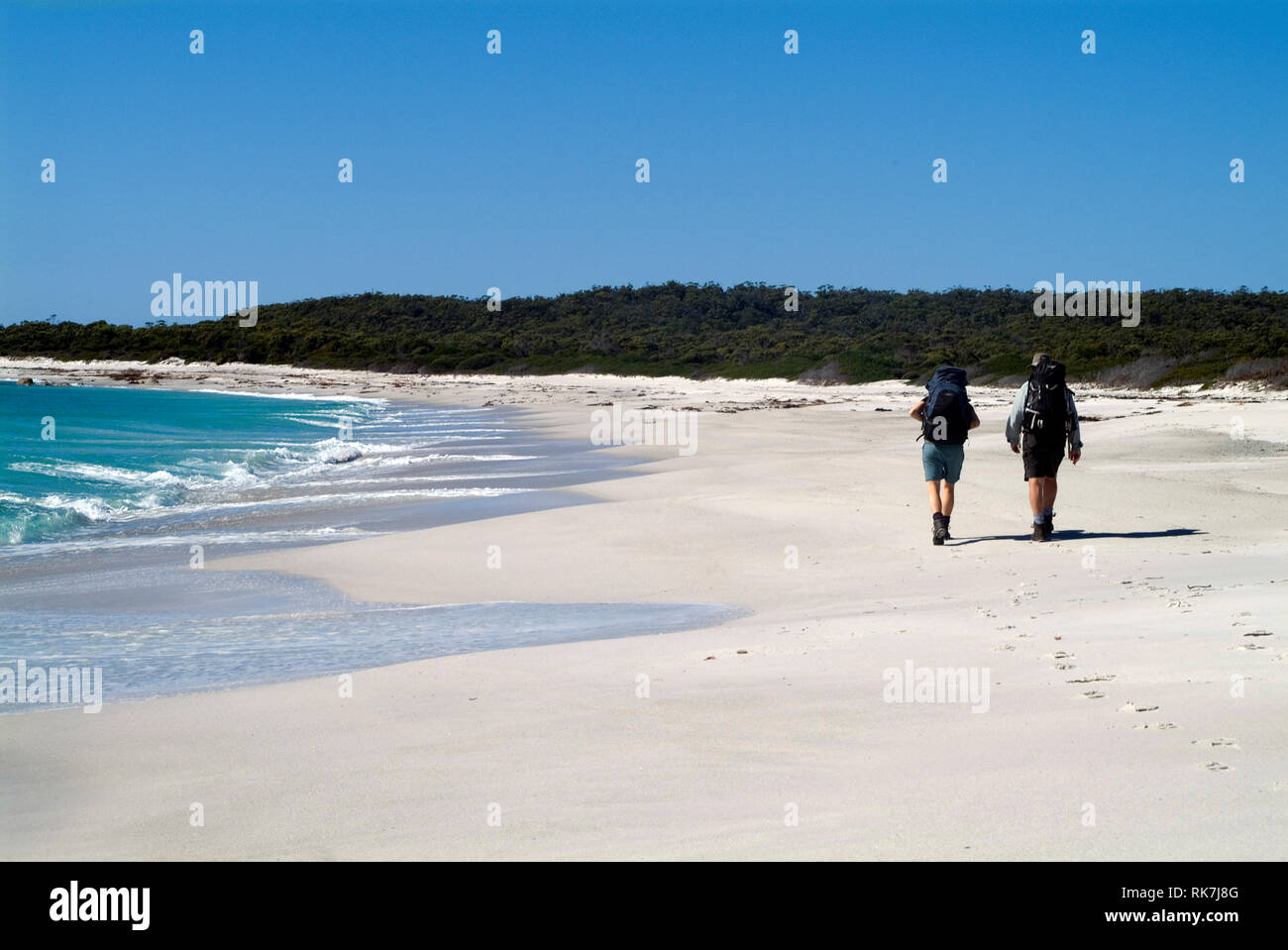 Guests of Cradle Mountain Huts walk along a remote beach on the Bay of Fires walk, a four-day hike that traverses Tasmania's far north-east coastline. Stock Photo