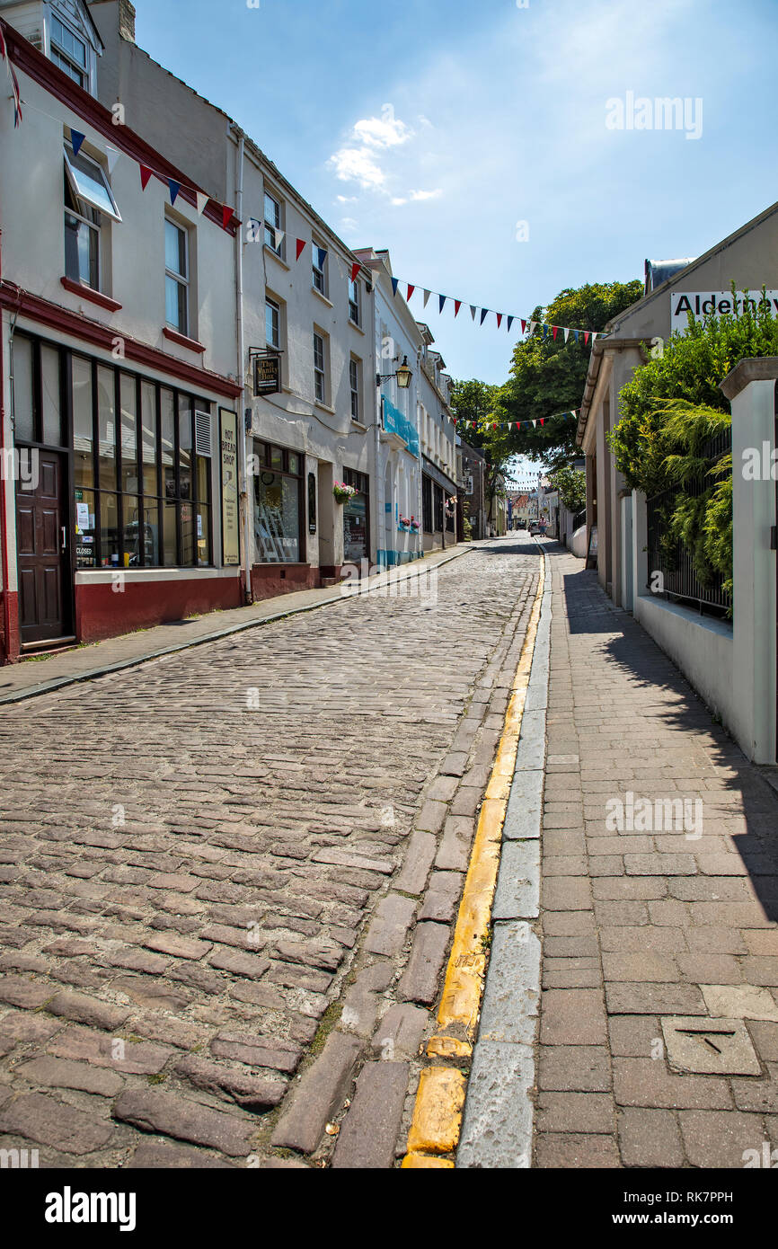 Colourful Victoria Street on Alderney Channel Islands showing typical crowds and complete lack of litter. Stock Photo