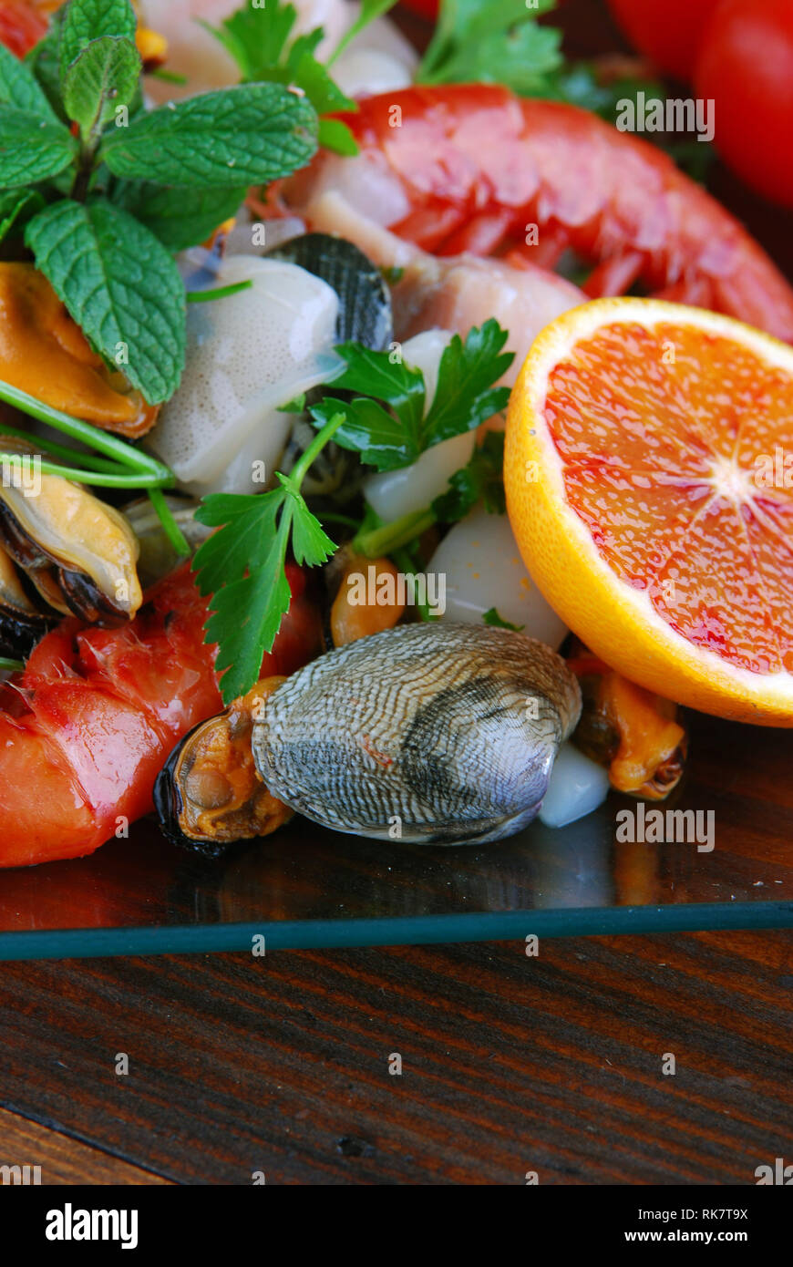glass dishes with fish bonito mollusks and shellfish raw on the wooden board Stock Photo