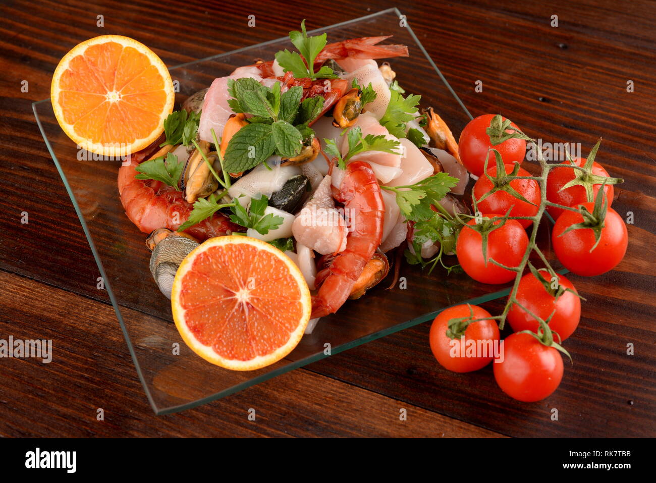 glass dishes with fish bonito mollusks and shellfish raw on the wooden board Stock Photo